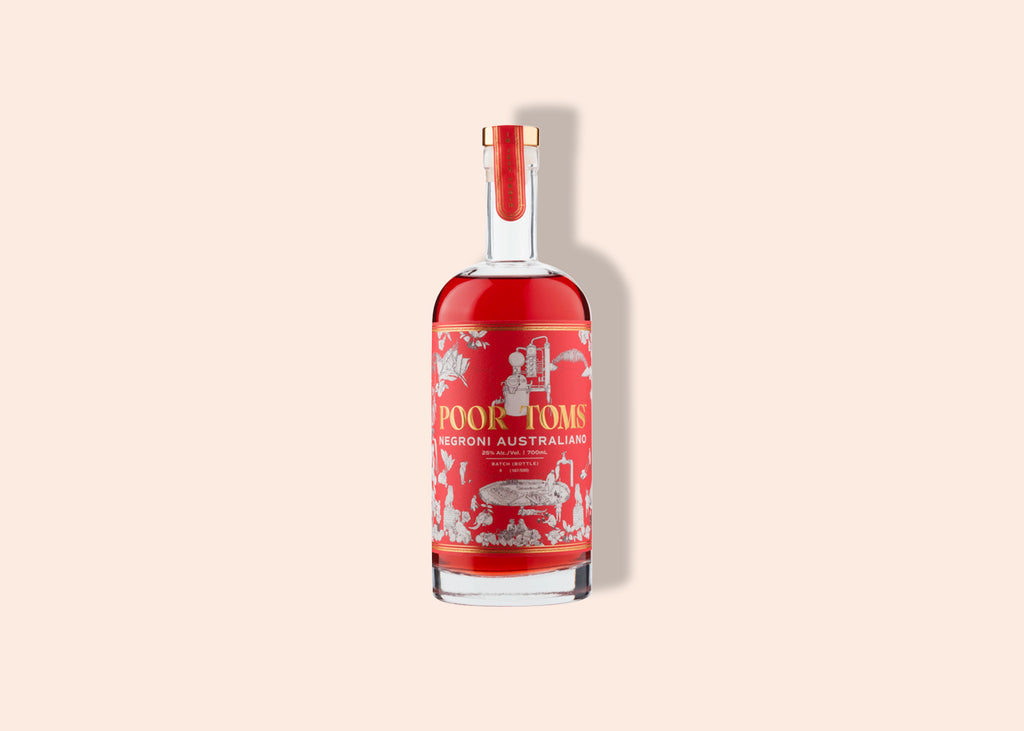 Clear bottle with long neck filled with negroni